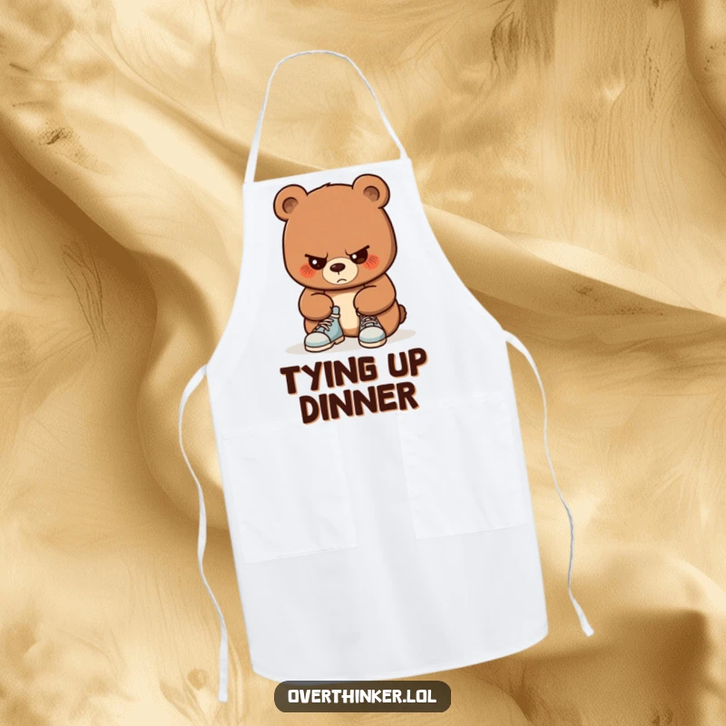 Funny apron with a bear concentrating intently on tying its shoelaces. Humorous and practical for protecting clothes while cooking.