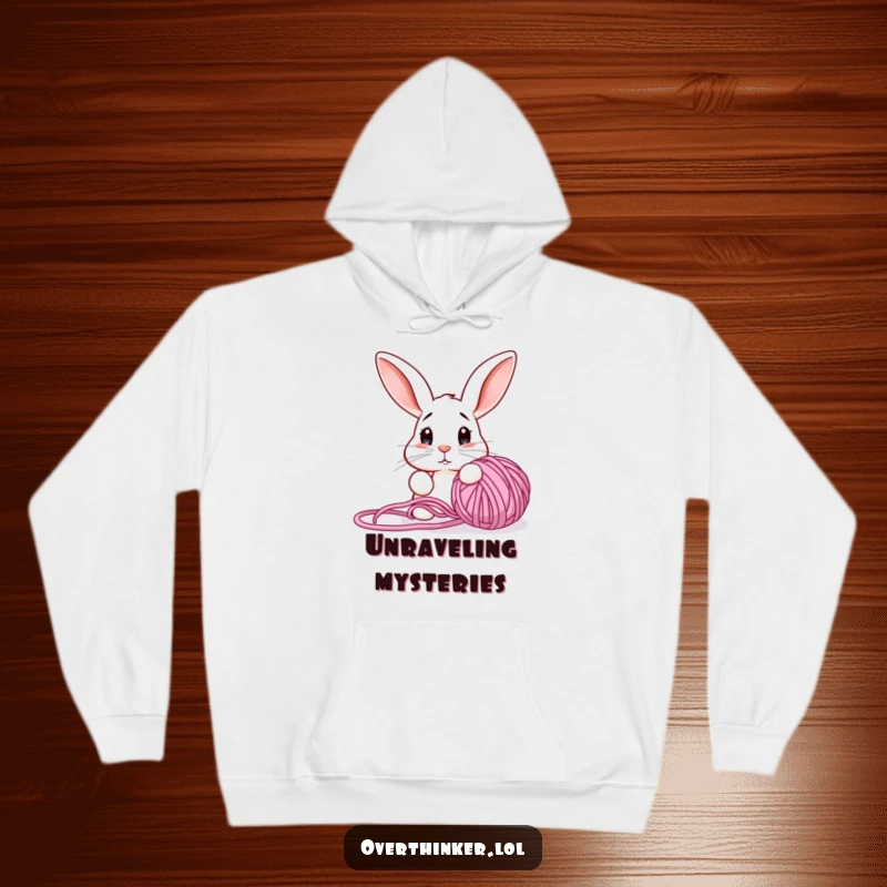 Funny hoodie with a confused rabbit staring at a tangled yarn ball, merging coziness with crafty humor.