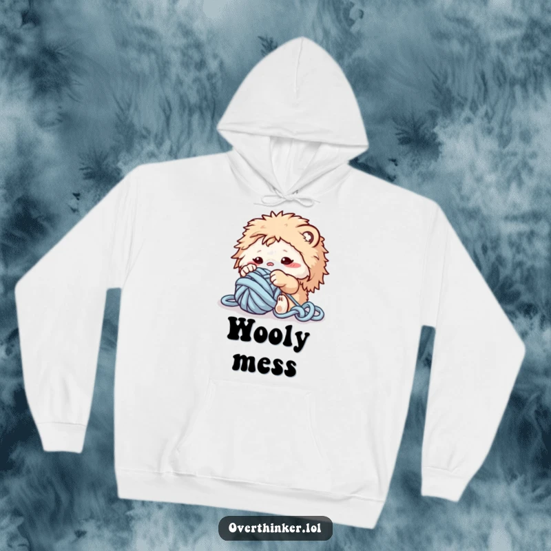 Funny hoodie featuring a fluffy creature playfully entangled in a large ball of yarn, ready for a cozy crafting session.